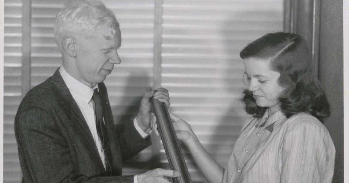 An Eckert-Mauchly Computer Corporation engineer and staff member hold a small mercury delay line memory tank used in the UNIVAC memory system, circa 1951. From the EMCC photograph collection, Hagley Museum and Library.